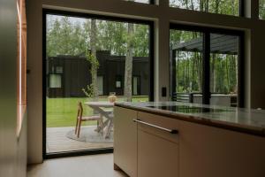 a kitchen with a view of a patio with a table at Jõelähtme Golf Villa with Sauna and Terrace Grill - near EGCC Golf Course in Manniva