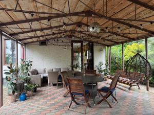 a patio with a table and chairs and a couch at Green Garden Hotel in Makhinjauri