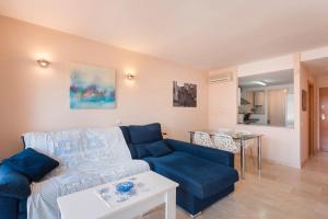 a living room with a blue couch and a table at Apartamento EntreOlas in El Verger