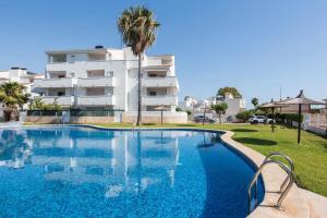 a swimming pool in front of a building at Apartamento EntreOlas in El Verger