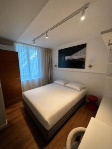 a bedroom with a large white bed in a room at Roxi Roosevelt in Antwerp