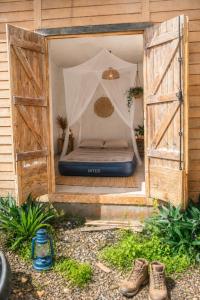 a bed in a room with two wooden doors at Papaya Camping in Les Abymes