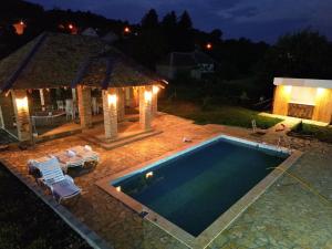 a swimming pool with a gazebo next to a house at Čajića avlija pool house in Obrenovac