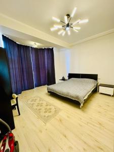 a bedroom with a bed and a ceiling fan at Квартира in Koshkolʼ