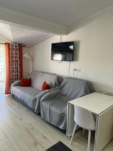a living room with a couch and a table at Квартира in Koshkolʼ