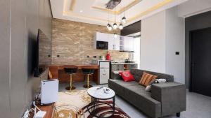 a living room with a couch and a kitchen at Richgates Apartments in Enugu