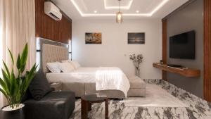 a bedroom with a bed and a couch and a chair at Richgates Apartments in Enugu