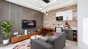 a living room with a gray couch and a kitchen at Richgates Apartments in Enugu +10 photos