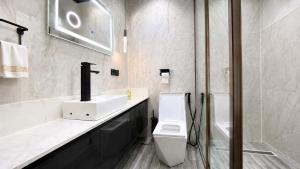 a bathroom with a white toilet and a sink at Richgates Apartments in Enugu