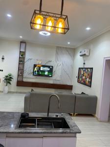 a kitchen with a sink and a tv in a room at Sandton Luxury Apartment in Bardon Yana