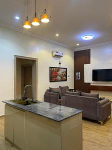 a kitchen and living room with a couch and a kitchen island at Sandton Luxury Apartment in Bardon Yana
