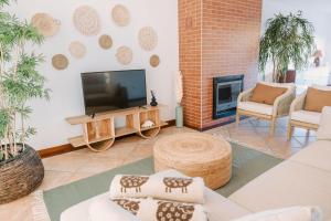 a living room with a tv and a fireplace at Casa do Suave Mar in Esposende