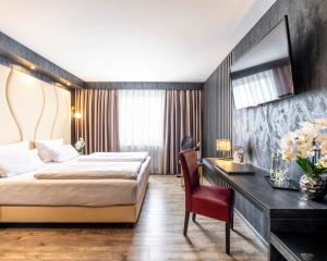 a hotel room with a bed and a desk at PLAZA INN Bruchsal in Bruchsal