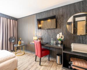a hotel room with a desk and a bed and a mirror at PLAZA INN Bruchsal in Bruchsal