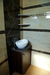 a bathroom with a bowl sink on a counter at Jazz Inn in Tiruvallūr