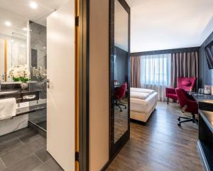 a hotel room with a bed and a bathroom at PLAZA INN Bruchsal in Bruchsal