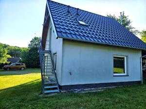 a small white house with a ladder next to it at Apartament Babina Loft in Żarkie Małe