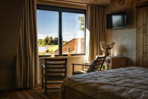 a bedroom with a window and two chairs and a bed at Guesthouse Ensenada in Schoondijke +52 photos