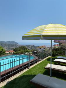 a balcony with an umbrella and a swimming pool at Casa Leonardo a Poggi in Imperia