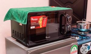 a microwave with a green towel on top of a stove at Dynasty homes in Bamburi