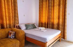 a bed and a couch in a room with curtains at Dynasty homes in Bamburi