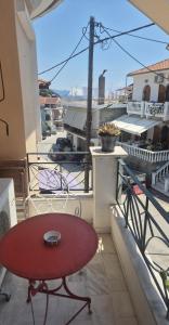 ein roter Tisch auf einem Balkon mit Aussicht in der Unterkunft Ilian House in Parga