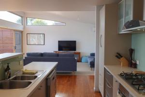 a kitchen and living room with a blue couch at Waterfront Primrose Retreat in Primrose Sands