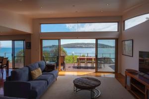 a living room with a couch and a view of the ocean at Waterfront Primrose Retreat in Primrose Sands