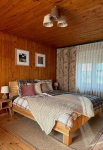 a bedroom with a bed and a wooden ceiling at Otuleni Kaszubami in Kiełpino