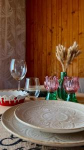 a table with a plate and wine glasses on it at Otuleni Kaszubami in Kiełpino +44 photos