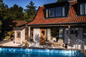 a brick house with a swimming pool in front of it at Guesthouse Ensenada in Schoondijke