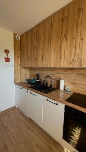 a kitchen with white cabinets and a sink at Otuleni Kaszubami in Kiełpino
