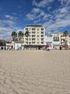 a large building on the beach with a playground at Apartamentos Wundermar in Torredembarra