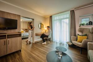 a man and a woman standing in a living room at Vitalhotel Bad Birnbach in Bad Birnbach
