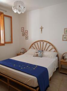 una camera da letto con un letto con una croce sul muro di Casa Poesia a Torre dell'Orso