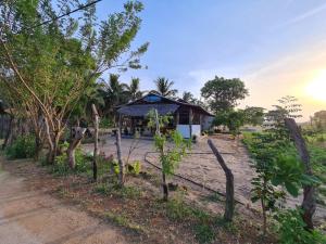 a small building with a blue canopy next to a dirt road at Kanthans Lighthouse Cabanas in Komari