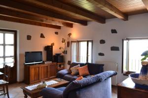 a living room with a couch and a tv at Casa vacanze Ivan Trinko in Savogna