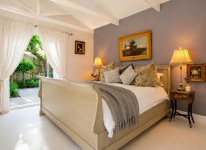 a bedroom with a bed and a window at Constantia French Cottage in Sweet Valley