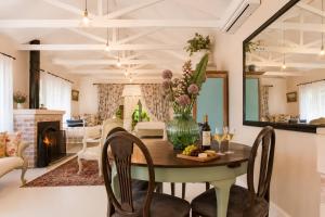 a living room with a table with a vase of flowers at Constantia French Cottage in Sweet Valley