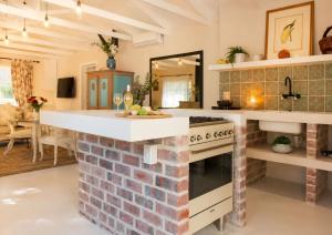 a kitchen with a brick wall and a stove at Constantia French Cottage in Sweet Valley