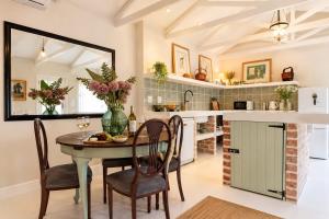 a kitchen with a table and chairs and a counter at Constantia French Cottage in Sweet Valley +23 photos
