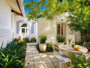 a patio with a table and chairs in front of a house at Constantia French Cottage in Sweet Valley
