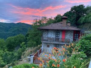 a house on a hill with a sunset in the background at Casa vacanze Ivan Trinko in Savogna