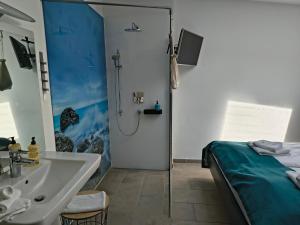 a bathroom with a sink and a shower and a bed at Meerhotel Großenbrode in Großenbrode +41 photos