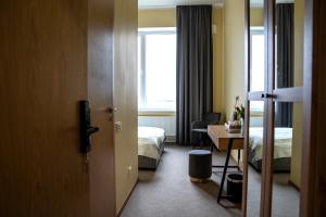 a hotel room with a bed and a desk and a window at Mangal Hotel in Olgina