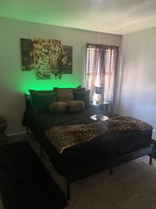 a bedroom with a bed with a green light at Cute 1bdr that sleep 4 minutes from ATT Stadium in Arlington