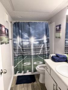 a bathroom with a baseball game shower curtain at Cute 1bdr that sleep 4 minutes from ATT Stadium in Arlington +2 photos