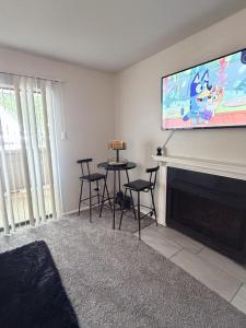 a living room with a tv and a table and chairs at Cute 1bdr that sleep 4 minutes from ATT Stadium in Arlington