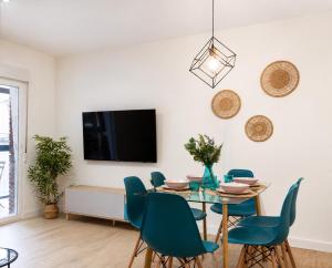 a dining room with a table and chairs and a tv at Apartamento Premium Ávila PLAZA MAYOR con PARKING in Ávila