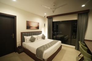 a bedroom with a bed and a large window at Mihas Hotels and Resorts in Malappuram